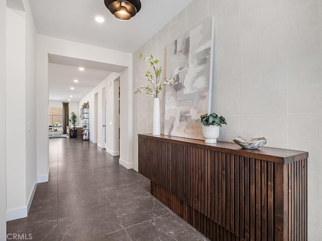 corridor with baseboards, recessed lighting, and marble finish floor
