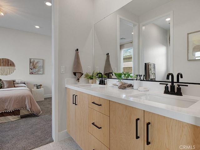 ensuite bathroom with recessed lighting, a sink, connected bathroom, and speckled floor