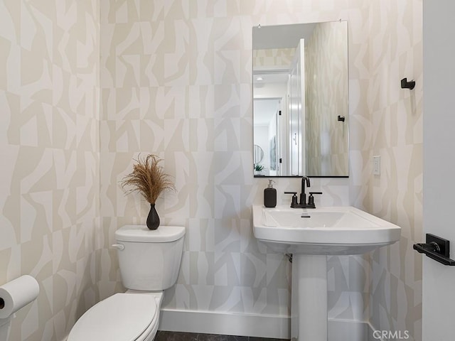 half bathroom with toilet and wallpapered walls