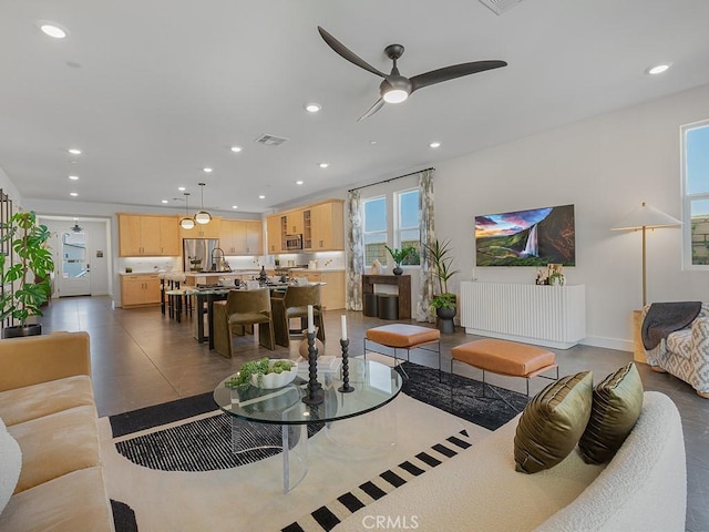 living area with a ceiling fan, recessed lighting, and visible vents