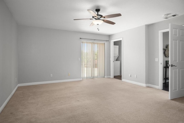 spare room with baseboards, ceiling fan, and light carpet