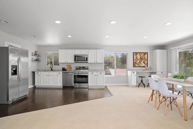 kitchen with stainless steel appliances, recessed lighting, white cabinetry, and a wealth of natural light