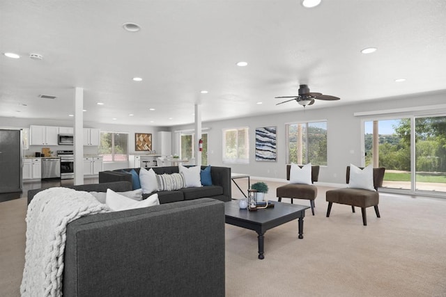 living room featuring ceiling fan, light carpet, recessed lighting, and a wealth of natural light
