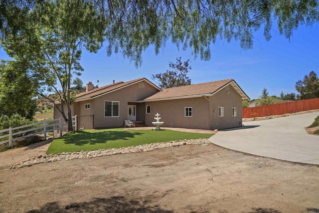 rear view of property featuring a patio, fence, and stucco siding