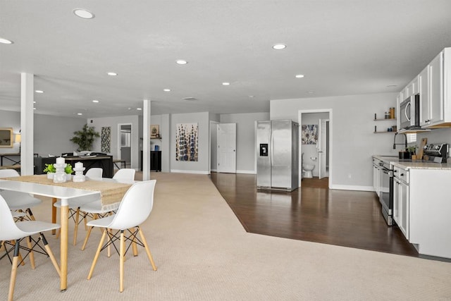 dining room featuring dark wood finished floors, baseboards, and recessed lighting