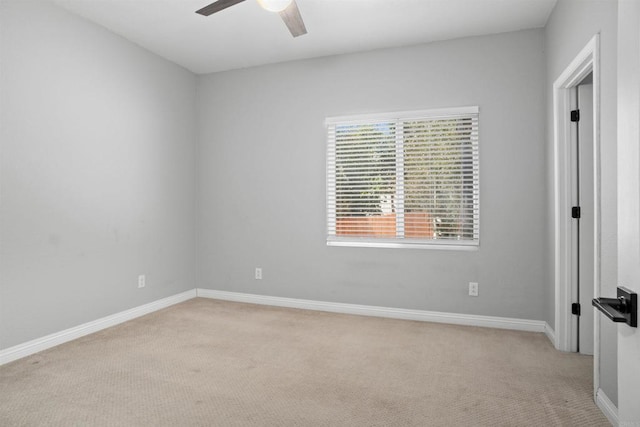 unfurnished room with ceiling fan, light colored carpet, and baseboards