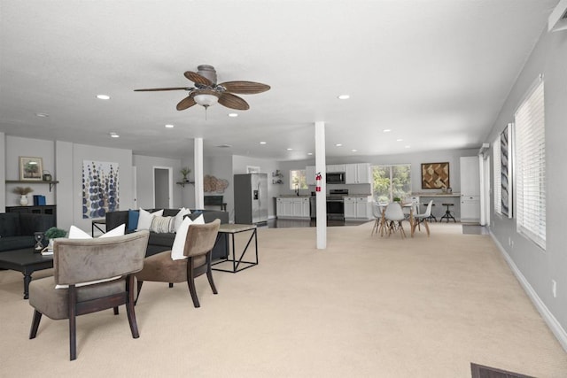 living area featuring light colored carpet, recessed lighting, baseboards, and ceiling fan