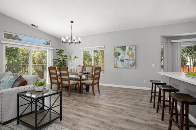 dining space featuring visible vents, an inviting chandelier, lofted ceiling, baseboards, and light wood-style flooring