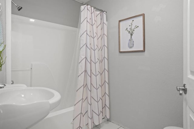 bathroom featuring tile patterned flooring, a sink, and shower / tub combo with curtain