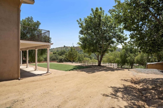 view of yard featuring fence, a patio, and a mountain view