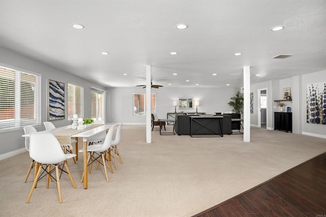 dining space with a ceiling fan, light colored carpet, light wood-type flooring, baseboards, and recessed lighting