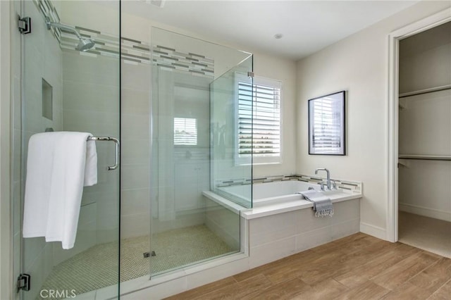 118 Tritone, Irvine, CA 92602 - full bathroom with wood finished floors, a spacious closet, a shower stall, baseboards, and a bath