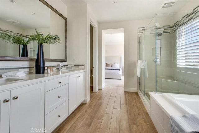 118 Tritone, Irvine, CA 92602 - full bath featuring a relaxing tiled tub, wood finished floors, a stall shower, baseboards, and vanity