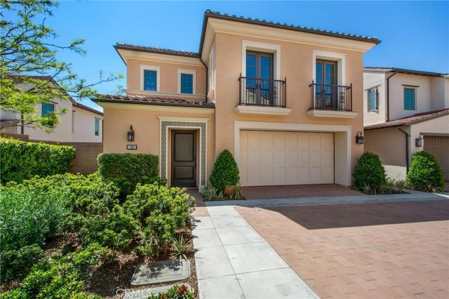 118 Tritone, Irvine, CA 92602 - view of front of property featuring a garage, stucco siding, a tile roof, decorative driveway, and a balcony