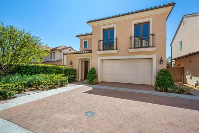 118 Tritone, Irvine, CA 92602 - mediterranean / spanish house featuring a tile roof, a garage, stucco siding, and a balcony
