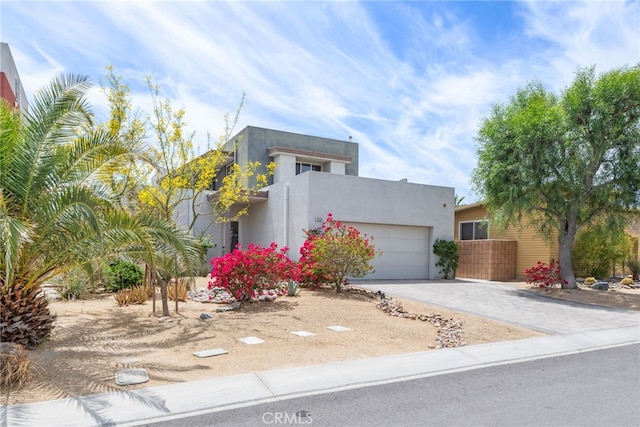 contemporary home with driveway, an attached garage, and stucco siding