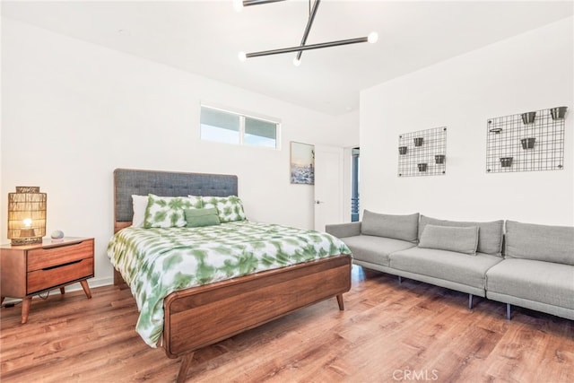 bedroom with light wood finished floors and a chandelier