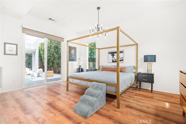 bedroom featuring access to exterior, wood finished floors, a chandelier, and baseboards