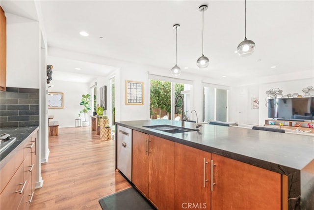 4934 Herzog Way, Palm Springs, CA 92262 - kitchen featuring stainless steel dishwasher, open floor plan, light wood finished floors, a kitchen island with sink, and decorative backsplash