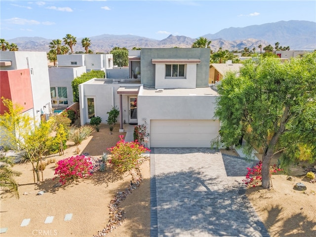 4934 Herzog Way, Palm Springs, CA 92262 - view of front of house featuring stucco siding, an attached garage, a mountain view, and decorative driveway