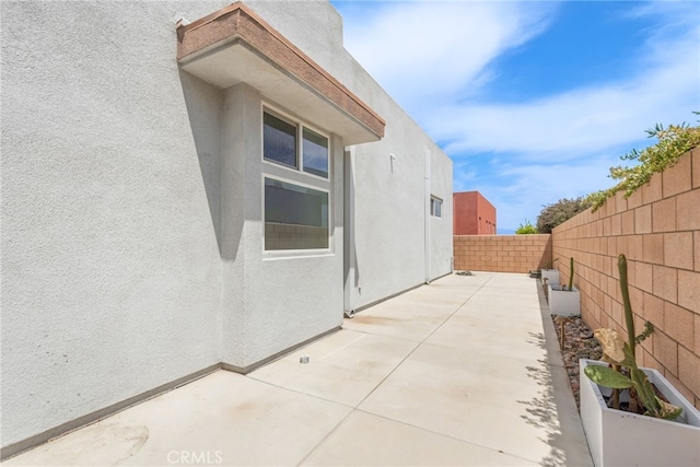 view of property exterior featuring a fenced backyard, stucco siding, and a patio