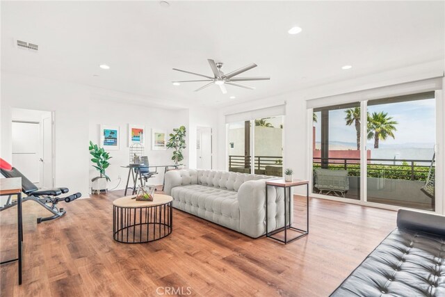 living area featuring ceiling fan, light wood finished floors, and recessed lighting