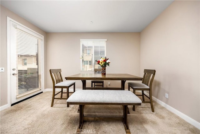 dining space featuring baseboards, light carpet, and a healthy amount of sunlight