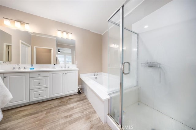 full bathroom with a sink, a garden tub, a stall shower, and double vanity
