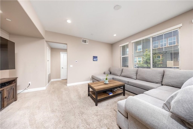living area with visible vents, recessed lighting, baseboards, and light colored carpet