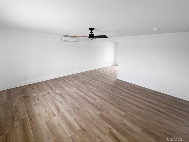 25244 Jade Rd, Barstow, CA 92311 - spare room featuring wood finished floors, a wall unit AC, ceiling fan, and baseboards