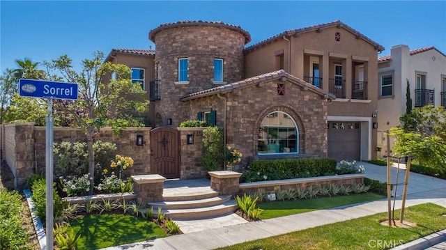 mediterranean / spanish home featuring a garage, stucco siding, a tile roof, and stone siding