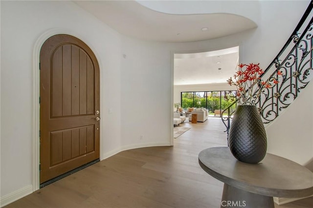 foyer entrance with baseboards and wood finished floors