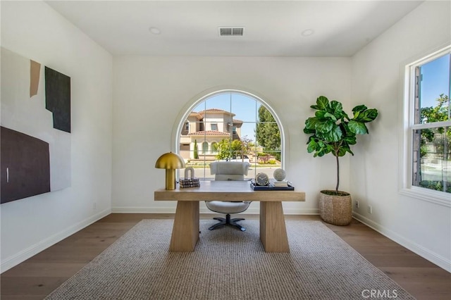 home office with wood finished floors and a wealth of natural light