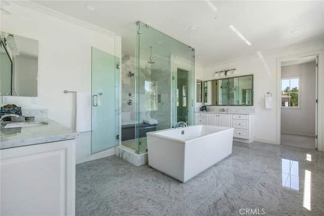 bathroom featuring baseboards, a freestanding bath, a shower stall, and a sink
