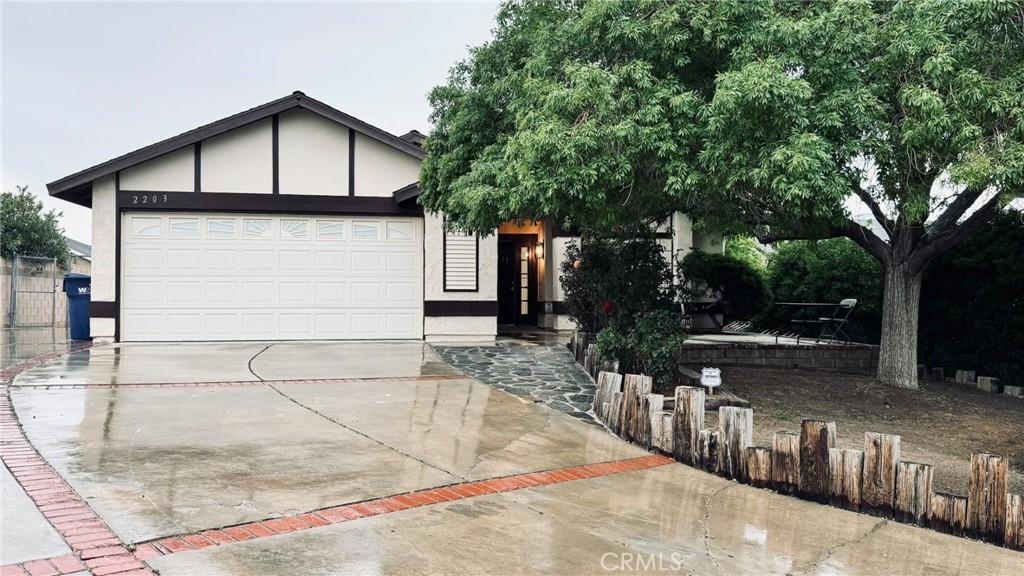 2203 Estrella Ct, Palmdale, CA 93550 - view of front of house featuring an attached garage, concrete driveway, and stucco siding