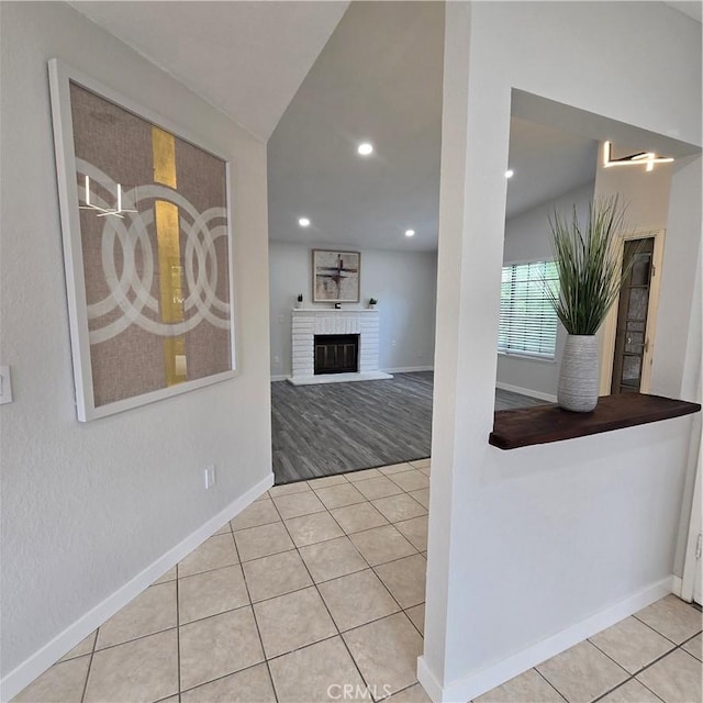 interior space featuring a brick fireplace, recessed lighting, tile patterned floors, and baseboards