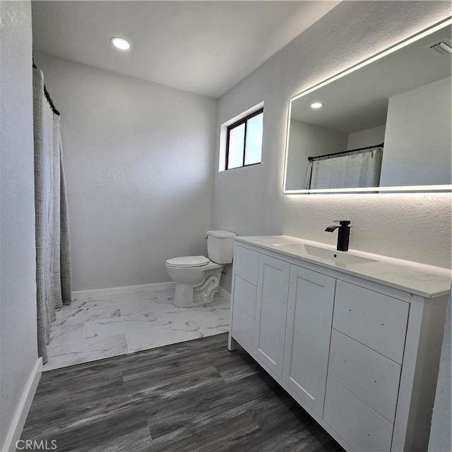 bathroom with recessed lighting, baseboards, vanity, and toilet