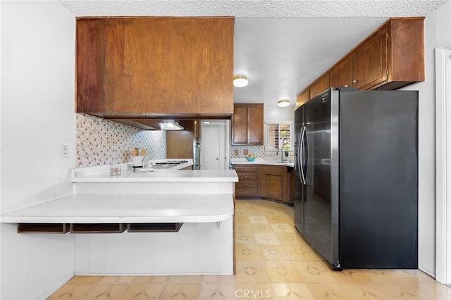 18502 Bellorita St, Rowland Heights, CA 91748 - kitchen with freestanding refrigerator, a peninsula, light countertops, backsplash, and a sink