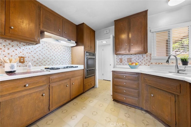 18502 Bellorita St, Rowland Heights, CA 91748 - kitchen featuring under cabinet range hood, a sink, light countertops, black oven, and backsplash