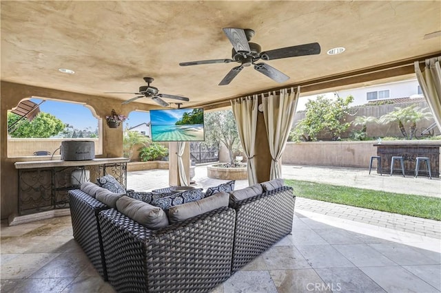 view of patio featuring ceiling fan, visible vents, outdoor dry bar, fence, and outdoor lounge area