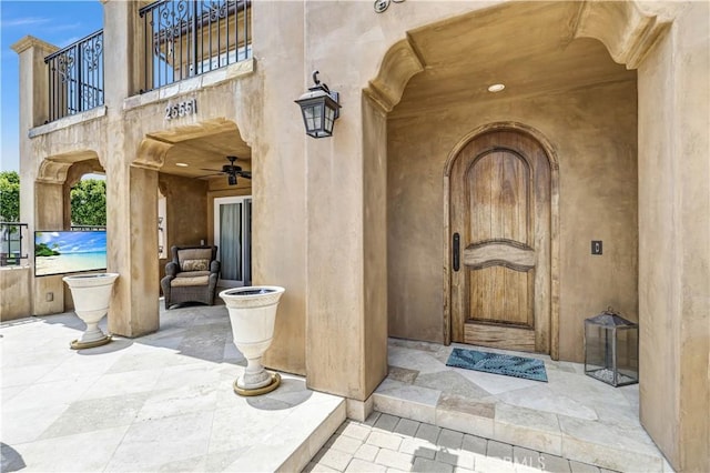 view of exterior entry with a patio and a balcony