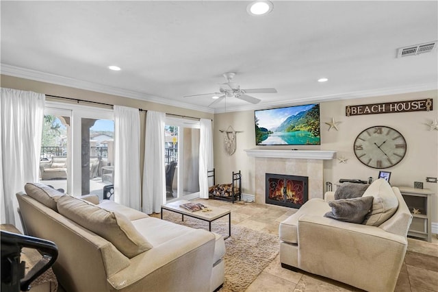 living room featuring crown molding, recessed lighting, visible vents, and a tile fireplace