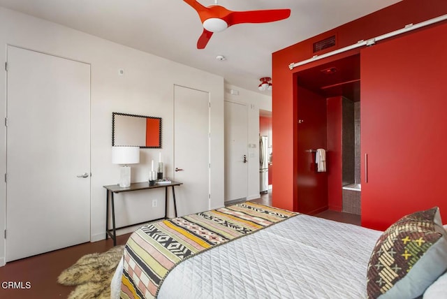 bedroom with freestanding refrigerator, a ceiling fan, and visible vents