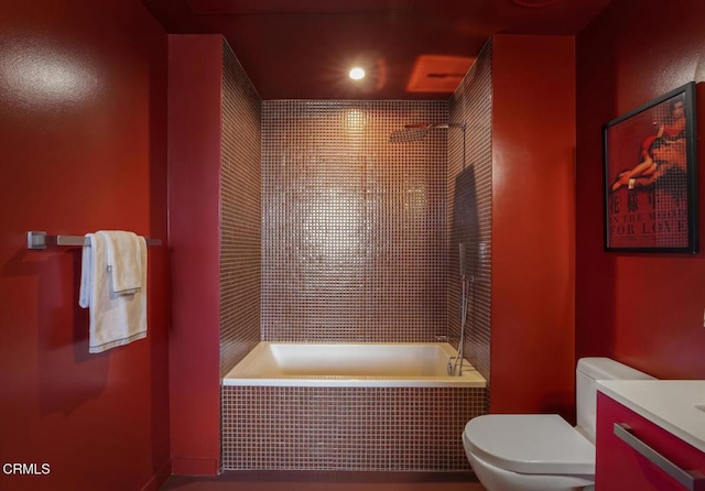 full bath featuring tiled shower / bath combo, toilet, and vanity