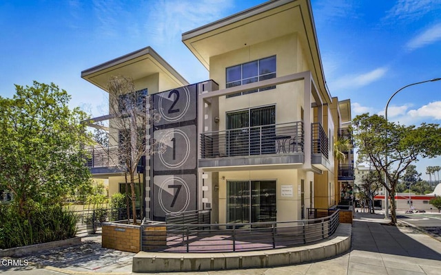 view of front of property with stucco siding and a balcony