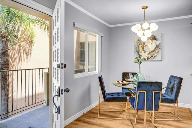 dining room with crown molding, baseboards, wood finished floors, and a chandelier