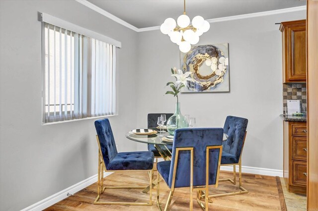 dining area featuring crown molding, baseboards, wood finished floors, and a chandelier