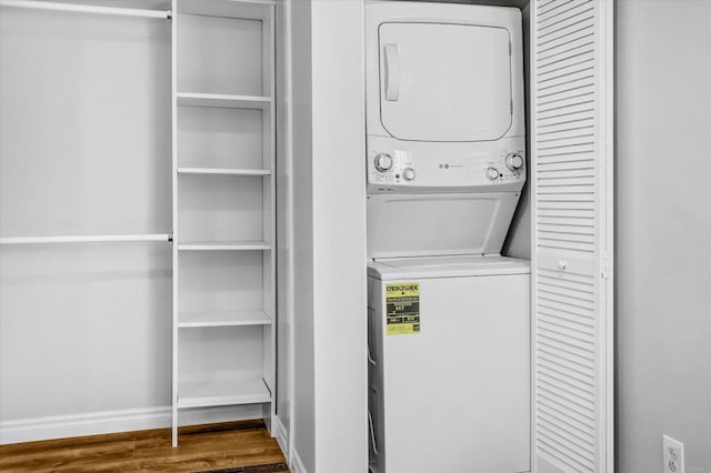 laundry room with laundry area, stacked washing maching and dryer, and wood finished floors