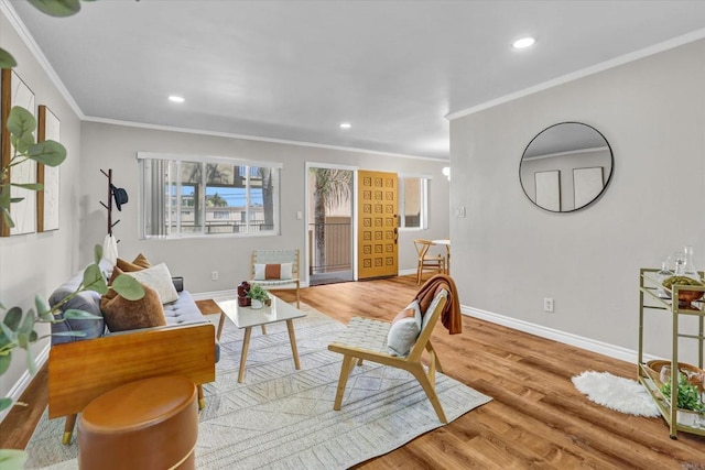 living area with baseboards, plenty of natural light, ornamental molding, and wood finished floors