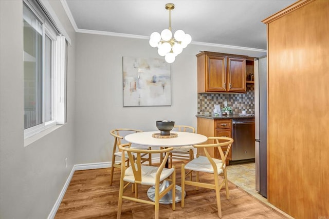 dining room featuring crown molding, light wood finished floors, a healthy amount of sunlight, and an inviting chandelier